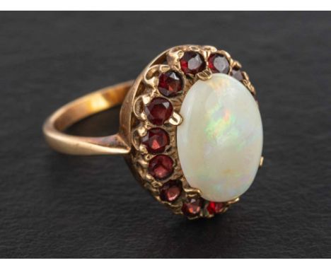 A 9ct gold cabochon-cut opal and garnet cluster ring,: estimated opal weight ca. 2.95cts, with hallmarks for London, 1972, le