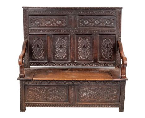 A Victorian carved oak settle, last quarter 19th century,: the rectangular backrest with relief carved friezes above two pane