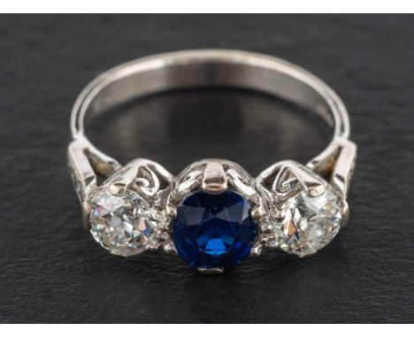 An 18ct gold, sapphire and round, brilliant-cut diamond, three-stone ring,: estimated total diamond weight ca. 0.90cts, G-H c