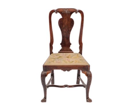 A Queen Anne walnut dining chair, early 18th century,: the back with acanthus carved toprail and solid vase splat, above a ta