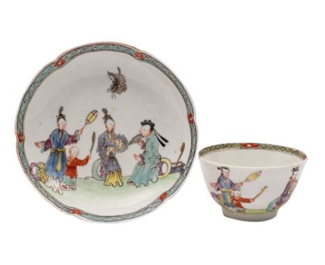 An early First Period Worcester famille rose matched tea bowl and saucer: painted with a family scene in a garden, a large bu