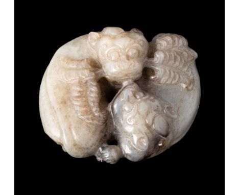 A Chinese jade carving: of two reclining mythical beasts, one holding leafy sprays in its mouth, the stone of celadon colour 