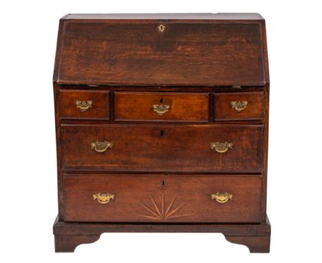 A George III oak bureau, circa 1770, the fall front opening to a fitted interior of drawers and pigeonholes, above three shor