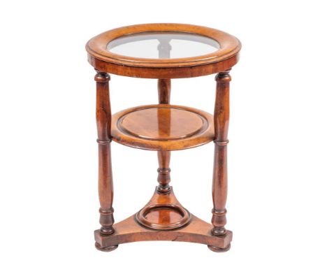 A Regency mahogany circular washstand, circa 1815,: the moulded outer edge enclosing a later glass shelf; on three knop turne