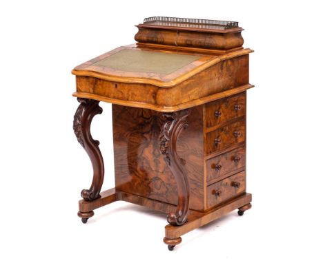 A Victorian walnut serpentine front Davenport, circa 1870,: the hinged top of the superstructure with brass three-quarter gal