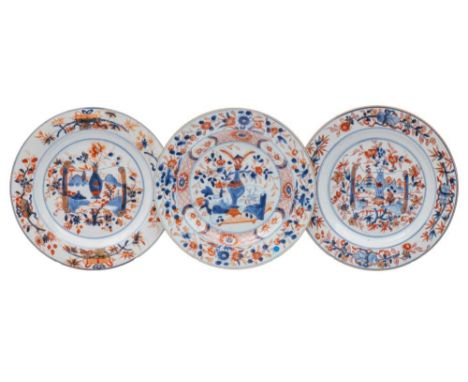 A group of three Chinese Imari plates: comprising a close pair and a single plate, painted with a large vase of flowers withi