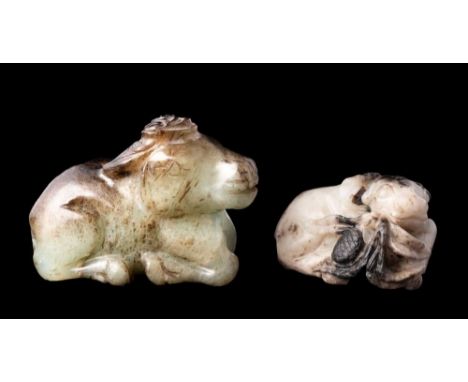 A  Chinese jade carving of a reclining buffalo and one other: the first of celadon and grey/russet colour, 5cm; the second of