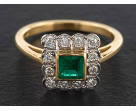 An 18ct gold step-cut emerald and round, brilliant-cut diamond cluster ring,: estimated emerald weight ca. 0.60ct, estimated 