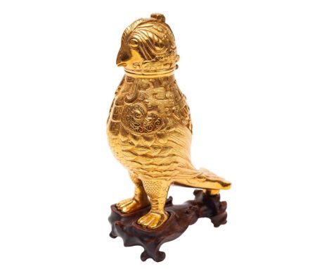 An Oriental gilt-metal bird box and hinged cover and a white metal pricket candlestick: the first in archaic style, modern, 1