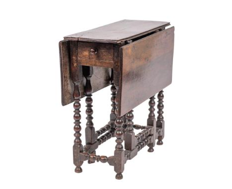 An oak gateleg table, last quarter 17th century,: of diminutive proportions; the rectangular top with twin drop leaves, a dra