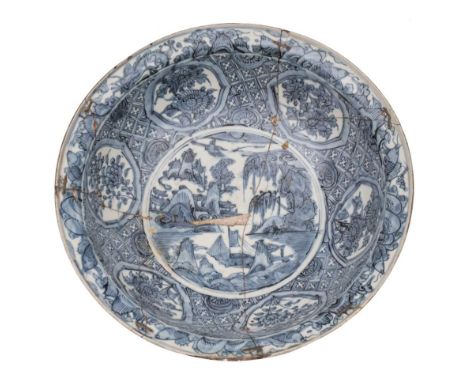 A large Chinese Swatow blue and white basin: painted with a medallion of trees, buildings and rockwork within a wide band of 