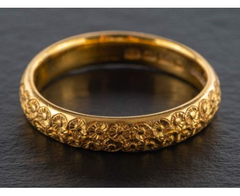 A 22ct gold band ring,: with chased floral decoration, hallmarks for Birmingham, 1927, ring size R, total weight ca. 6.1gms.