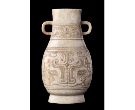 A Chinese pale celadon and grey jade archaistic vase: of flattened baluster form with simple loop handles, finely carved over