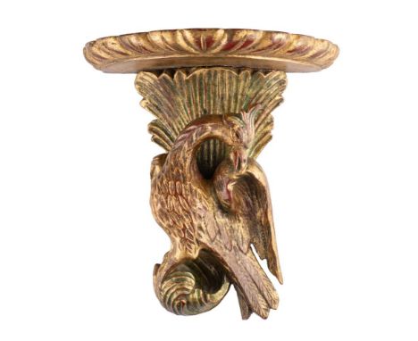 An early 19th century style giltwood wall bracket: the semi-round shelf supported by an exotic bird and foliage, 21cm high.