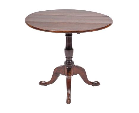 A George II mahogany circular occasional table, mid 18th century,: the flip top above a turned 'gun barrel' stem, on three sp