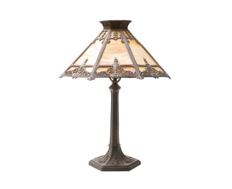 An American metal and glass table lamp: of octagonal design, the shade with opaque panels and flaming urn decoration, raised 