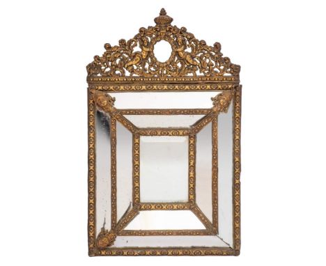 A Dutch repousse brass framed marginal wall mirror, in 17th century style, late 19th century,: the cresting with urn finial a