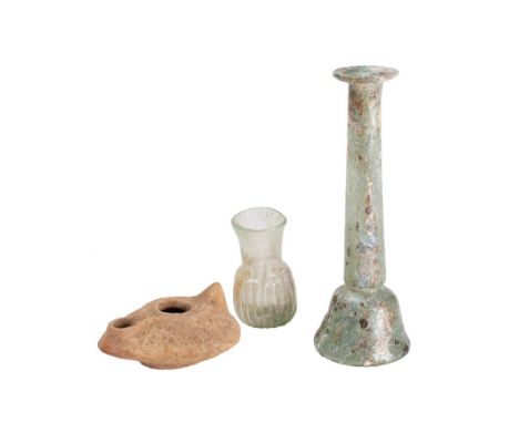 A Roman glass bottle: of slender bell-shaped form, a smaller ribbed glass bottle  and a pottery oil lamp. (3).