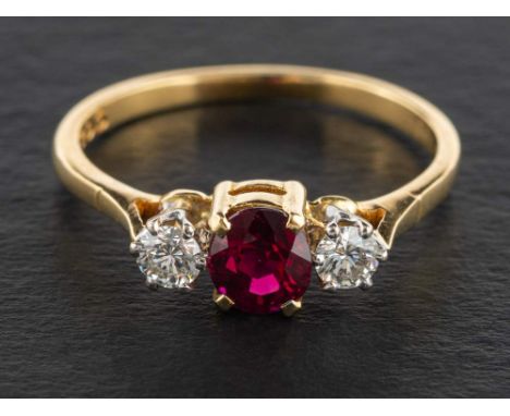 An 18ct gold, ruby and round, brilliant-cut diamond three stone ring,: estimated total diamond weight ca. 0.30ct, H-I colour,