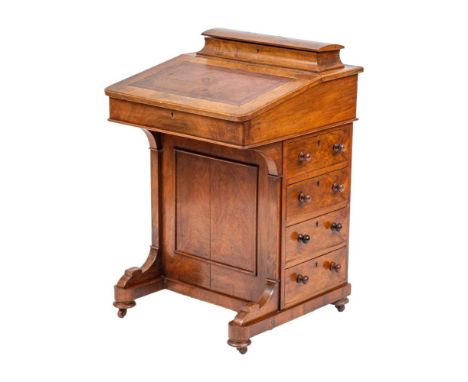 A Victorian walnut Davenport, circa 1870,: the superstructure with hinged cover and divisions within, above a hinged sloping 