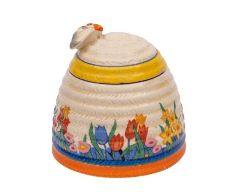 A Clarice Cliff beehive honey pot and cover: of ribbed form, the cover with bee finial, decorated in the Chloris pattern, pri