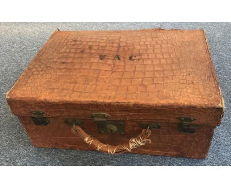 A vintage crocodile skin suitcase with leather compartmented interior and deep red lining, three locks all working and made b