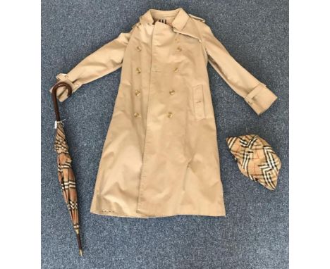 A ladies vintage Burberry trench coat in beige, with traditional collar, epaulettes, belt and signature Burberry check lining