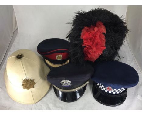 A Scottish Piper's ostrich feather bonnet with red and white checked band, together with a New Zealand Police peaked cap, US 