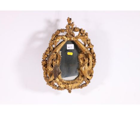 Antique gilded gesso wall mirror of roughly oval shape, the mirror flanked by a pair of eagle surround by oak leaf and acorn 