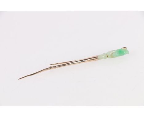 Chinese 10ct gold stick brooch in the form of a torch, the carved jade finial in the form of a hand holding a fish, stamped "