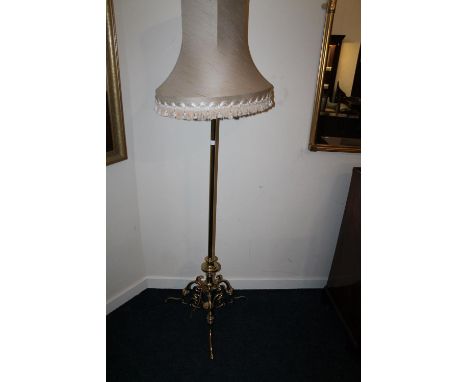 Early 20th century brass standard lamp raised on ornate tripod base, 178cm tall including shade. 