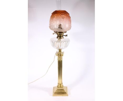 Early 20th century brass oil lamp, with a later shade and funnel, above a Young's lever and glass reservoir, on a Corinthian 