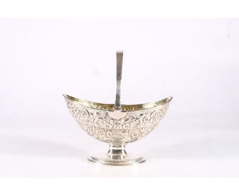 Antique sterling silver swing handled basket of navette shape with gilded interior and heavy foliate embossed decorated body,