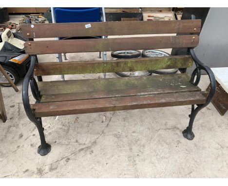 A VERY HEAVY WOODEN BENCH WITH CAST IRON ENDS 