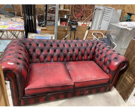 AN OX BLOOD LEATHER BUTTON BACK TWO SEATER SOFA 