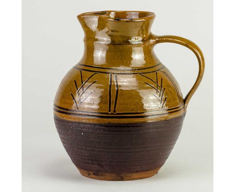 † MICHAEL CARDEW (1901-1983) for Winchcombe Pottery; a slipware jug with simple abstract sgraffito decoration under a mangane