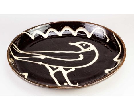 † MICHAEL CARDEW (1901-1983) for Winchcombe Pottery; a very large oval slipware dish decorated with a bird on black ground, i