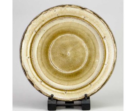 JIM MALONE (born 1946); a stoneware charger covered in green ash glaze with incised decoration, impressed JM and L (for Lesso