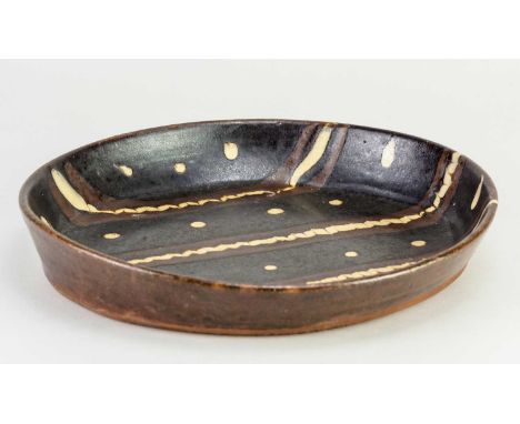 † Attributed to MICHAEL CARDEW (1901-1983) for Winchcombe Pottery; an oval slipware dish with trailed and feathered decoratio