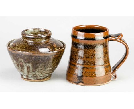 Leach Pottery; a stoneware mug covered in tenmoku breaking to kaki glaze, impressed pottery mark, height 12.5cm, and a bowl a