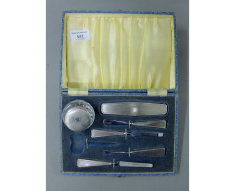 A cased Art Deco silver manicure set (lacking scissors). The case 21.5 cm wide.