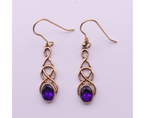 A pair of 9 ct gold and amethyst Celtic rope design earrings. 2.5 cm high. 3.3 grammes total weight.