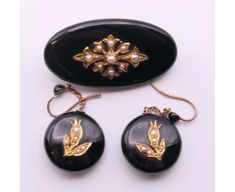 A suite of Victorian seed pearl mounted mourning jewellery, comprising of a pair of earrings and a brooch. The brooch 3.5 cm 