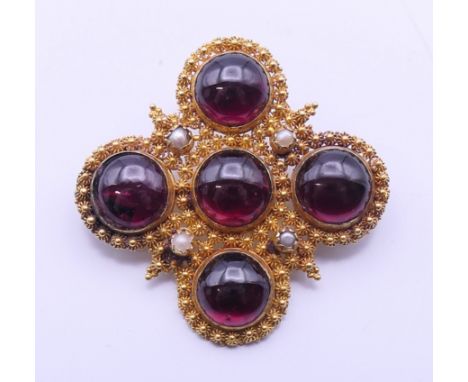 A 19th century unmarked gold, garnet and seed pearl set brooch. 3.75 cm wide.