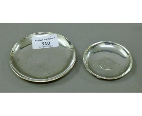 Two small Chinese silver dishes, one set with a coin. The largest 9 cm diameter. 88.6 grammes total weight.