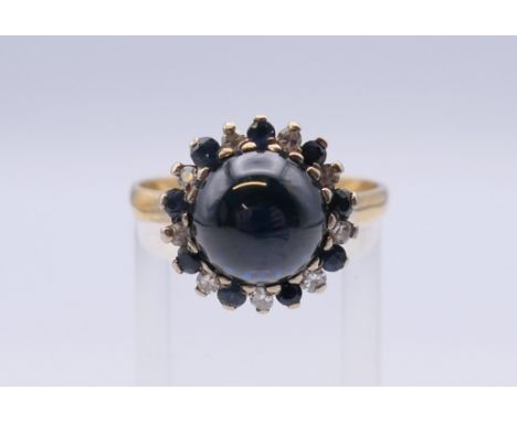 An unmarked gold cabochon sapphire and diamond ring. Ring size R/S. 