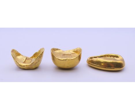 Three Chinese gold coloured scroll weights. The largest 5 cm long.