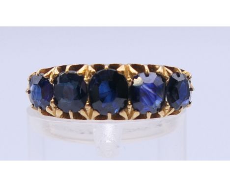 A 19th century unmarked gold five stone sapphire ring. Approximate sapphire weight 5.5 carats. Ring size L/M.