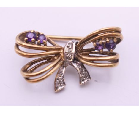 A 9 ct gold diamond and amethyst bow form brooch. 2.5 cm wide. 3.4 grammes total weight.