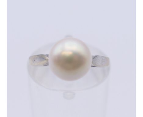 An 18 ct white gold solitaire pearl ring. Ring size I/J. 3.1 grammes total weight.